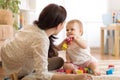 Adorable baby girl playing with educational toys in nursery. Child having fun with colorful different toys at home