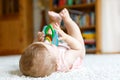 Adorable baby girl playing with educational toys in nursery. Happy healthy child having fun with colorful different toys Royalty Free Stock Photo