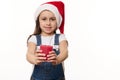 Adorable baby girl in Santa hat with a lit red candle in hands. Cute kid makes cherished wish for Christmas. Copy space Royalty Free Stock Photo