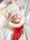 Adorable baby girl in Santa hat lying on the bed Royalty Free Stock Photo