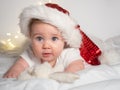 Adorable baby girl in Santa hat lying on the bed Royalty Free Stock Photo
