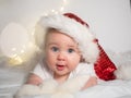 Adorable baby girl in Santa hat lying on the bed and smiling Royalty Free Stock Photo