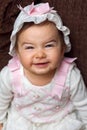 Adorable Baby Girl Smiling With a Scrunched Face She is Wearing Royalty Free Stock Photo