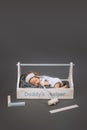 adorable baby with hammer in hand sleeping in wooden toolbox with daddys