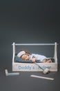 adorable baby with hammer in hand sleeping in wooden toolbox with daddys