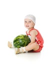 An adorable baby happily plays the watermelon