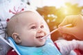 Adorable baby have lunch with spoon at the table