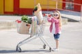 A little girl with a big trolley buys fresh food and vegetables in a big supermarket in the summer alone. Royalty Free Stock Photo