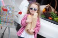 A little girl with a big trolley buys fresh food and vegetables in a big supermarket in the summer alone. Royalty Free Stock Photo