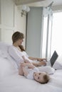 Adorable Baby Lying Beside Mother Using Laptop Royalty Free Stock Photo