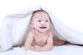 Adorable baby lying under blanket - isolated Royalty Free Stock Photo