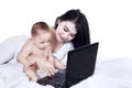 Adorable baby with mom working on a laptop Royalty Free Stock Photo