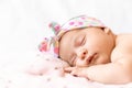 Adorable baby newborn with a headband sleeping on stomach Royalty Free Stock Photo