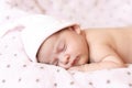 Adorable baby newborn sleeping on stomach on a soft blanket. A newborn baby in a hat sleeps on a soft blanket Royalty Free Stock Photo