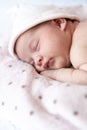 Adorable baby newborn sleeping on stomach on a soft blanket. A newborn baby in a hat sleeps on a soft blanket Royalty Free Stock Photo