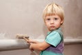 Adorable baby painting the wall with a brush. Royalty Free Stock Photo