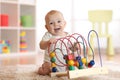 Adorable baby playing in nursery. Happy healthy child having fun with colorful toy at home. Royalty Free Stock Photo