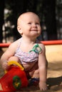 Adorable baby plays in a sandbox