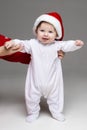 Adorable baby in Santa hat and white footie.