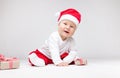 Adorable baby wearing a Santa hat opening Christmas presents Royalty Free Stock Photo