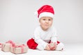 Adorable baby wearing a Santa hat opening Christmas presents Royalty Free Stock Photo