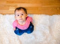 Adorable baby on white carpet looking up. Copy space on right Royalty Free Stock Photo