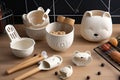 adorable baking tools and equipment in shapes of animals, such as a bear with mixing bowls and whisks