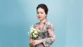 Adorable  beautiful woman holding bouquet of flowers isolated on blue background Royalty Free Stock Photo