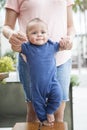 Adorable bi-racial baby boy learning to walk with the help of his mother Royalty Free Stock Photo