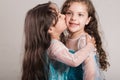 Adorable big and little sister wearing matcing blue dresses posing together happily, studio background Royalty Free Stock Photo