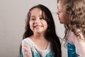 Adorable big and little sister wearing matcing blue dresses posing together happily, studio background Royalty Free Stock Photo