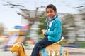 Adorable black boy on carousel in the park