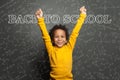 Adorable black child smart student boy on chalkboard background. Back to school concept