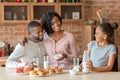 Adorable black family of three having breakfast at kitchen Royalty Free Stock Photo