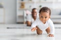 Adorable Black Infant Baby Crawling Away From Father At Home