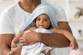 Adorable Black Infant Baby In Towel Relaxing In Father& x27;s Arms After Bath Royalty Free Stock Photo