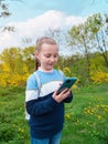 Adorable blogger child girl chatting in social media smartphone learning language listening audio books podcast outdoor Royalty Free Stock Photo