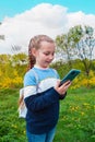 Adorable blogger child girl chatting in social media smartphone learning language listening audio books podcast outdoor Royalty Free Stock Photo