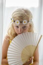 Adorable blond girl holding white fan Royalty Free Stock Photo