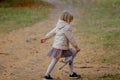 Adorable blond girl playing and jumping with her favorite toy grey cat on a beautiful autumn day. Royalty Free Stock Photo