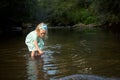 Adorable blond girl playing in river, exploration concept Royalty Free Stock Photo