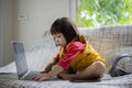 Adorable blond toddler boy laying on the sofa and playing with pc at home Royalty Free Stock Photo