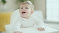 Adorable blonde baby smiling confident sitting on highchair at home Royalty Free Stock Photo