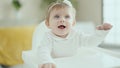 Adorable blonde baby smiling confident sitting on highchair at home Royalty Free Stock Photo