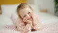 Adorable blonde girl smiling confident lying on bed at bedroom Royalty Free Stock Photo