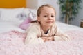 Adorable blonde girl smiling confident lying on bed at bedroom Royalty Free Stock Photo