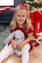 Adorable blonde girl smiling confident sitting on floor by christmas tree at home Royalty Free Stock Photo