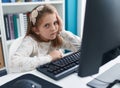 Adorable blonde girl student tired using computer at classroom