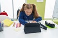 Adorable blonde girl student using touchpad writing notes at classroom Royalty Free Stock Photo