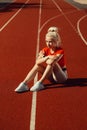 Adorable blonde sits on a jogging track